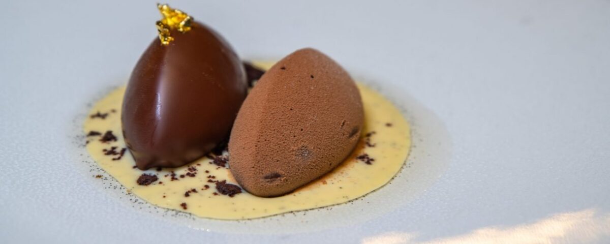 Rijks Amsterdam Two pieces of Rijks chocolate on a white plate.
