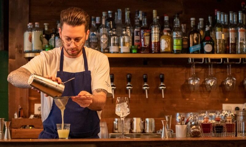 A man pouring a drink at Cambridge Public House.