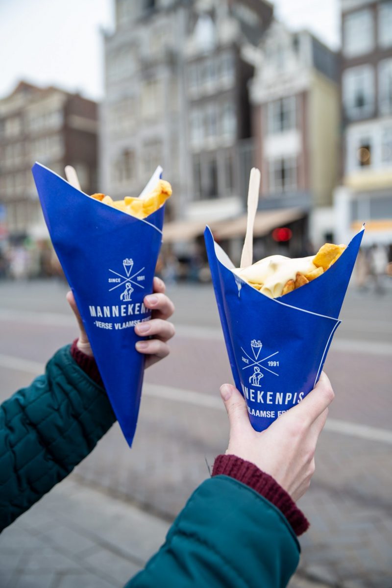 a couple holding some food in Amsterdam.