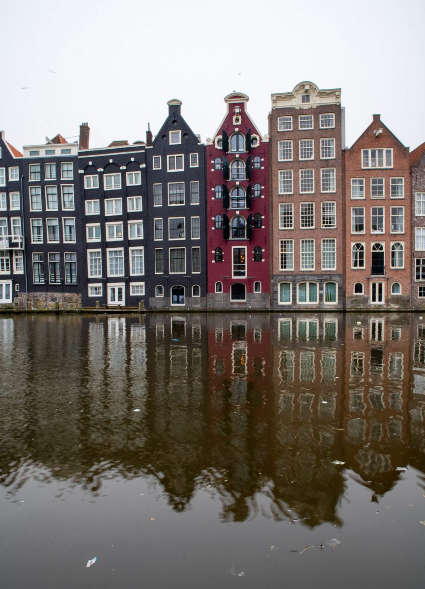 A row of buildings next to a body of water in Amsterdam.