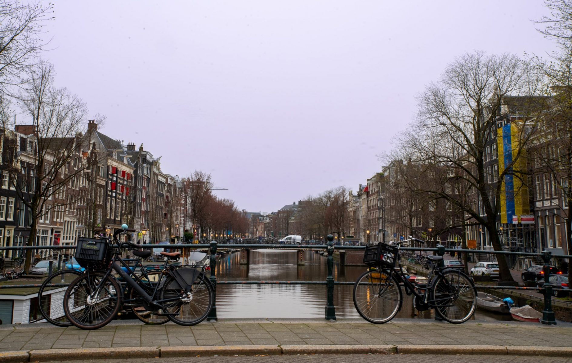 Two bikes parked on a street in Amsterdam.