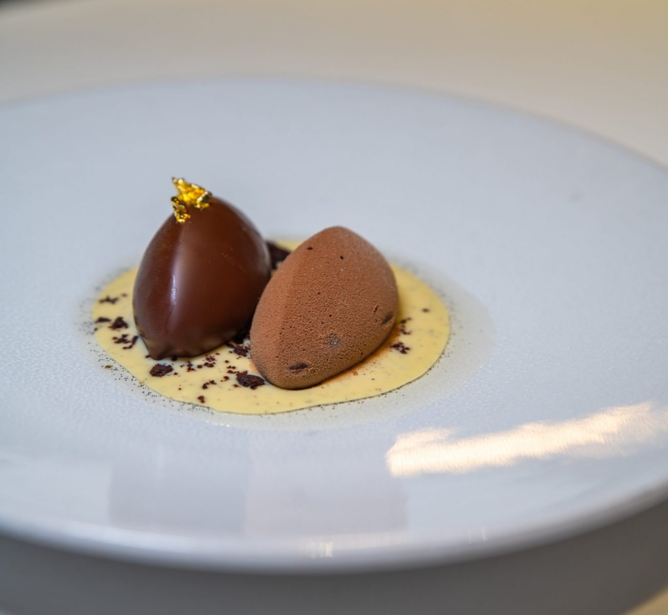 two pieces of chocolate on a white plate.