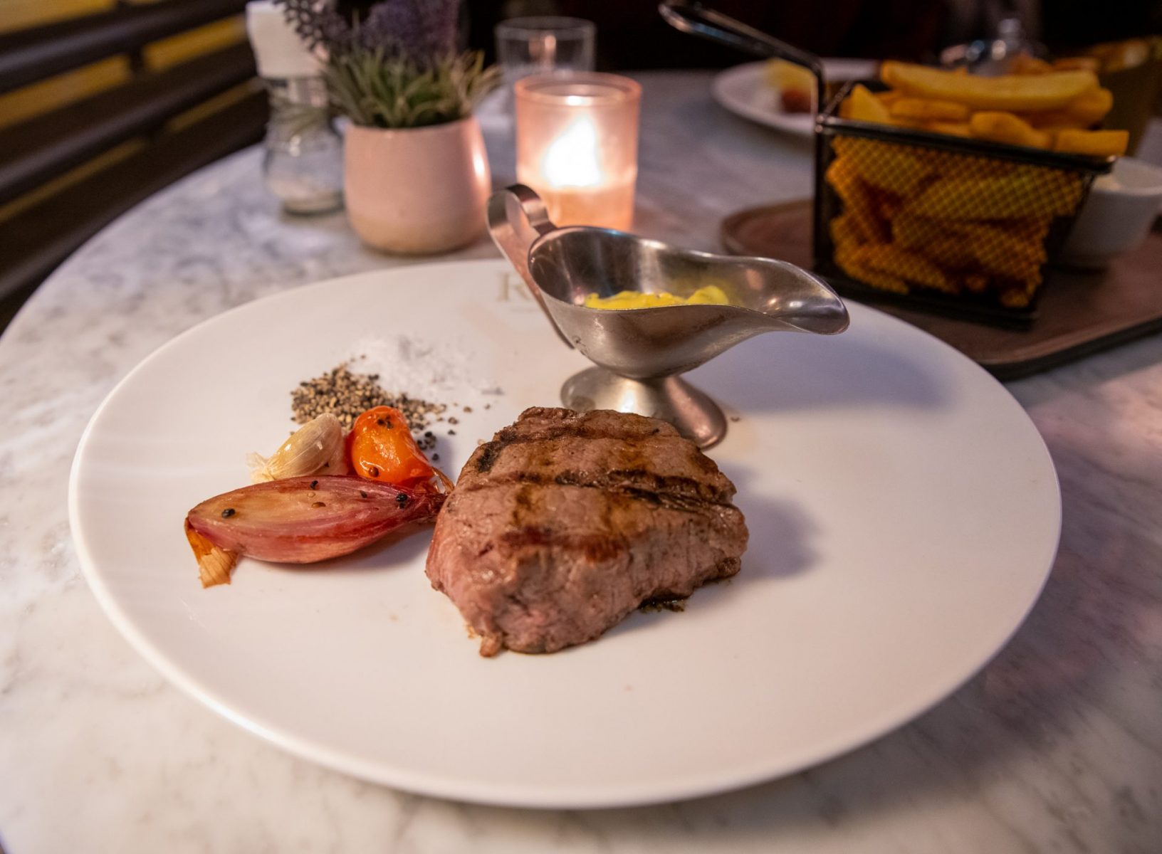 a white plate topped with meat and vegetables.