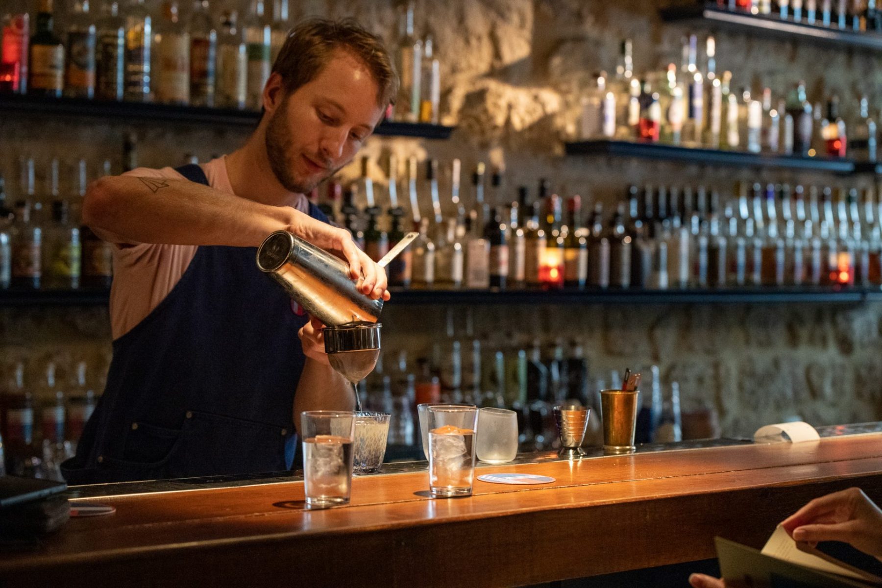 A bartender pouring a drink at Little Red Door in Paris.