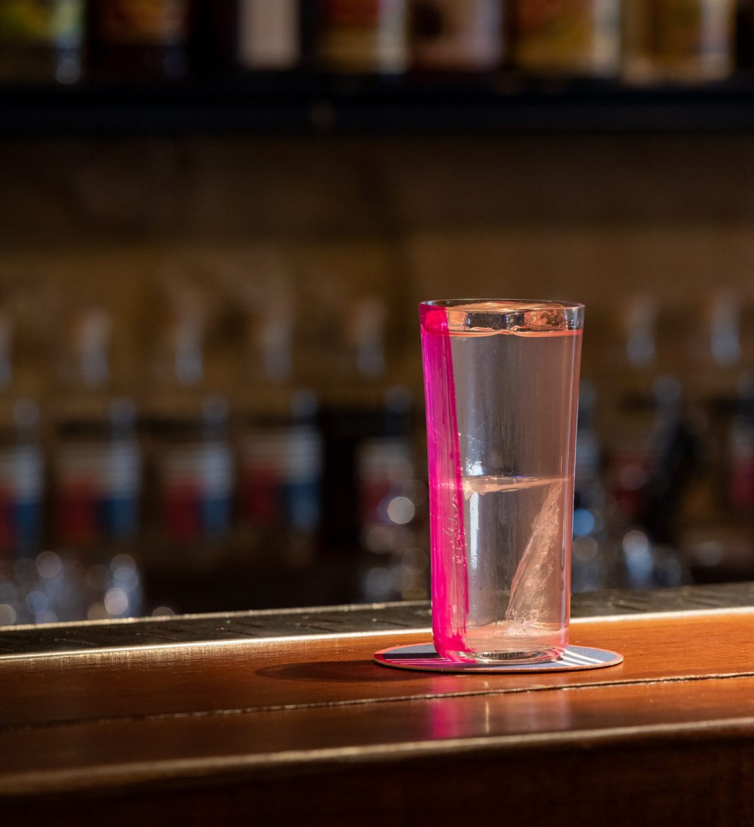 A Little Red Door shot glass sitting on a Parisian bar top.