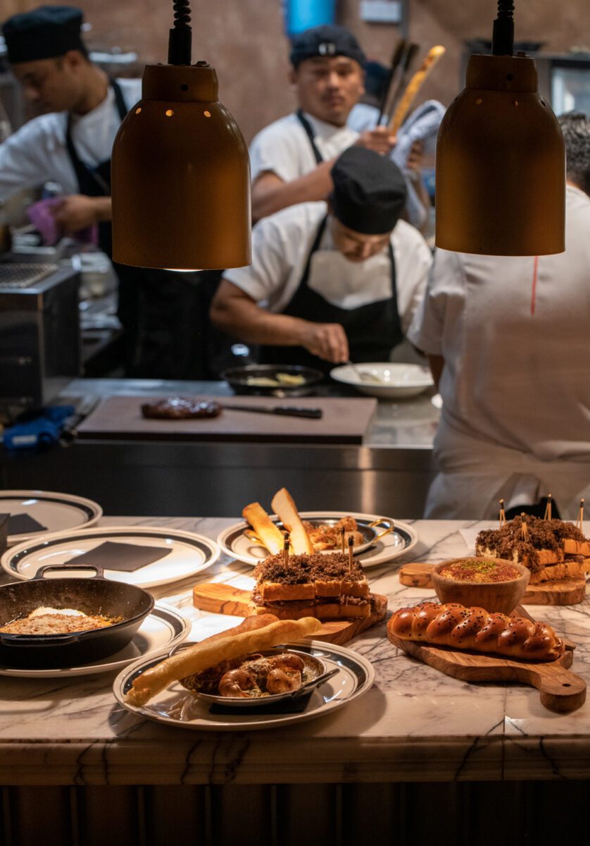 A group of chefs preparing food in a kitchen at RSVP Dubai.