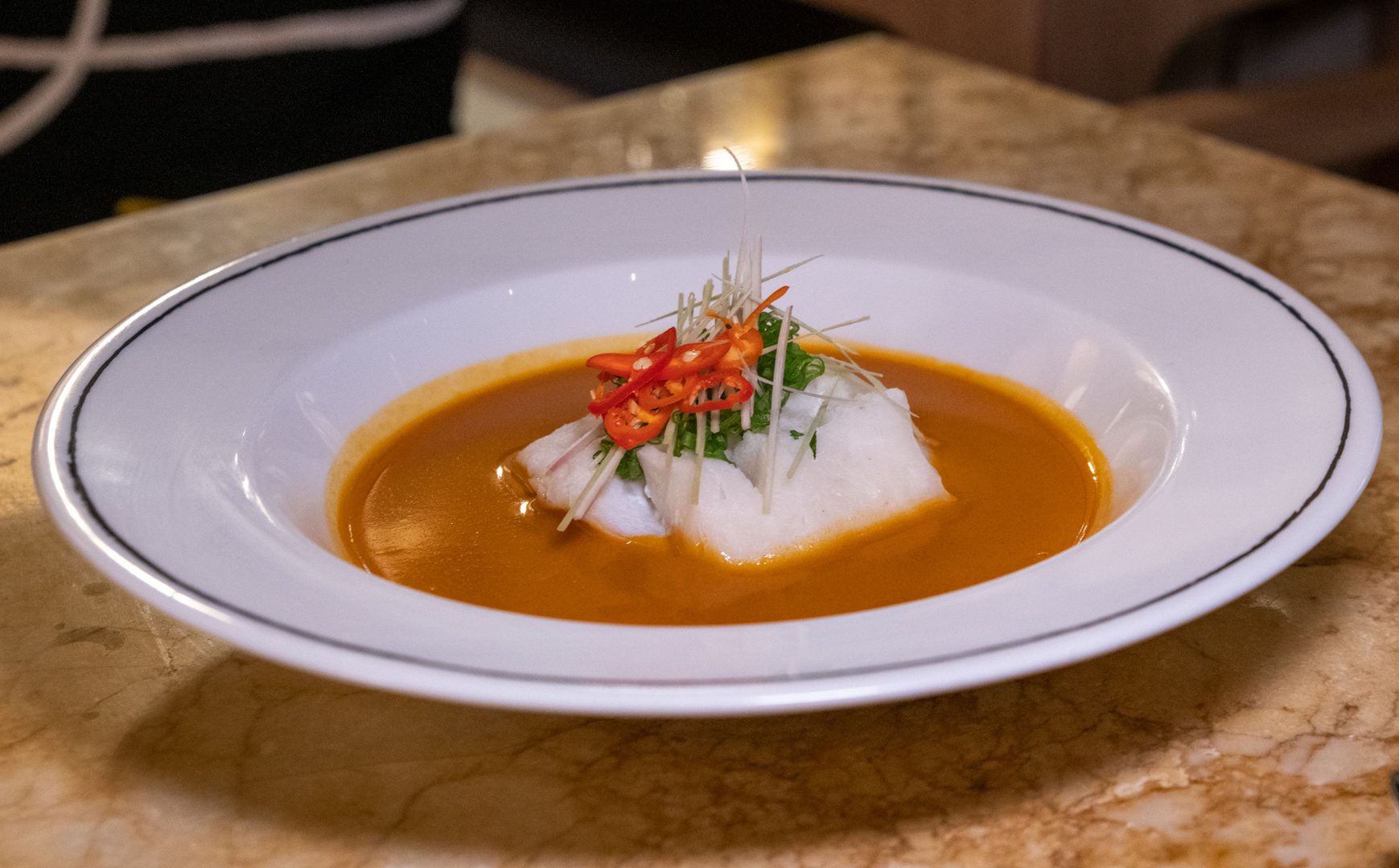 a white bowl filled with soup on top of a table.