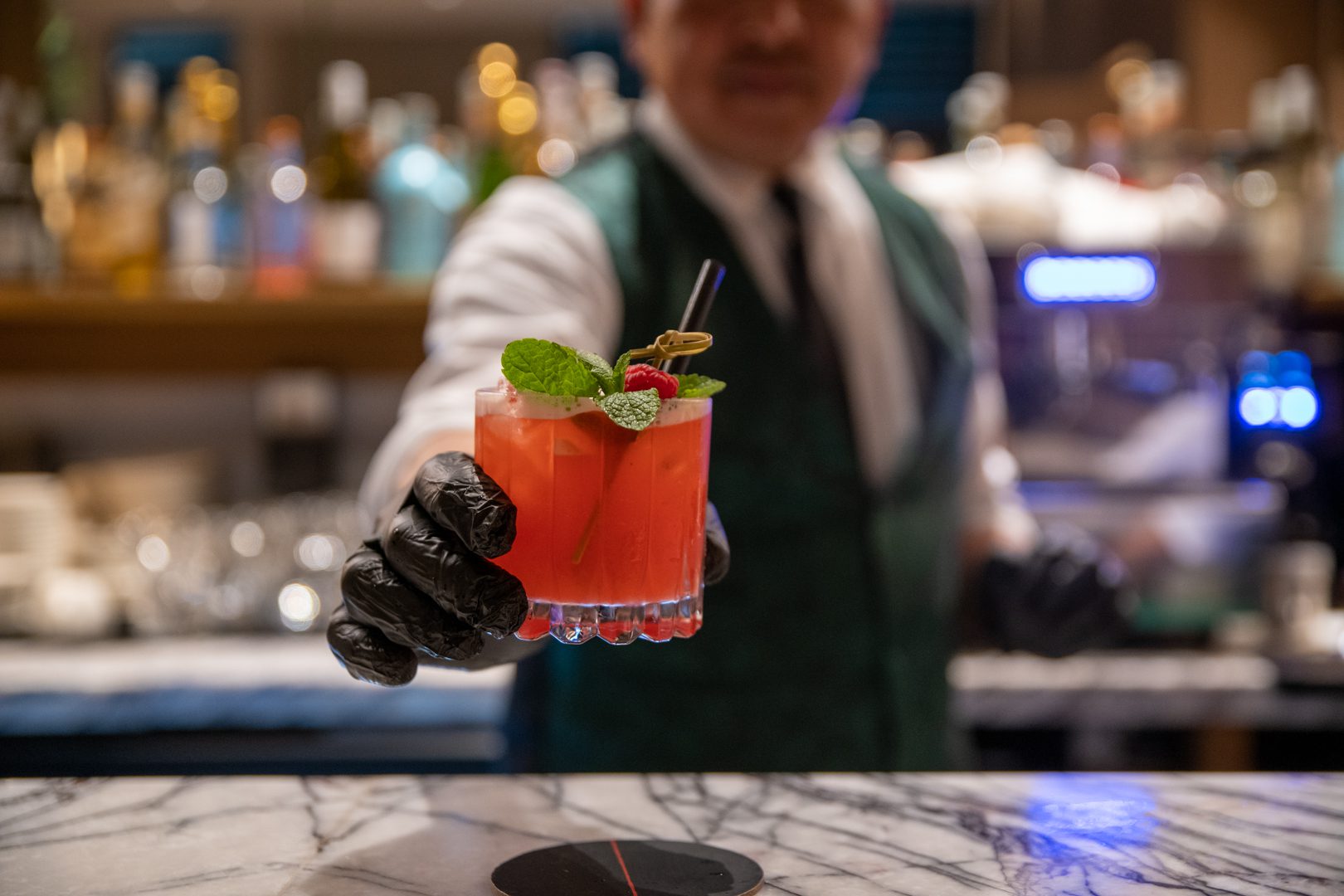 A bartender is holding a cocktail in his hand at the RSVP Dubai event.