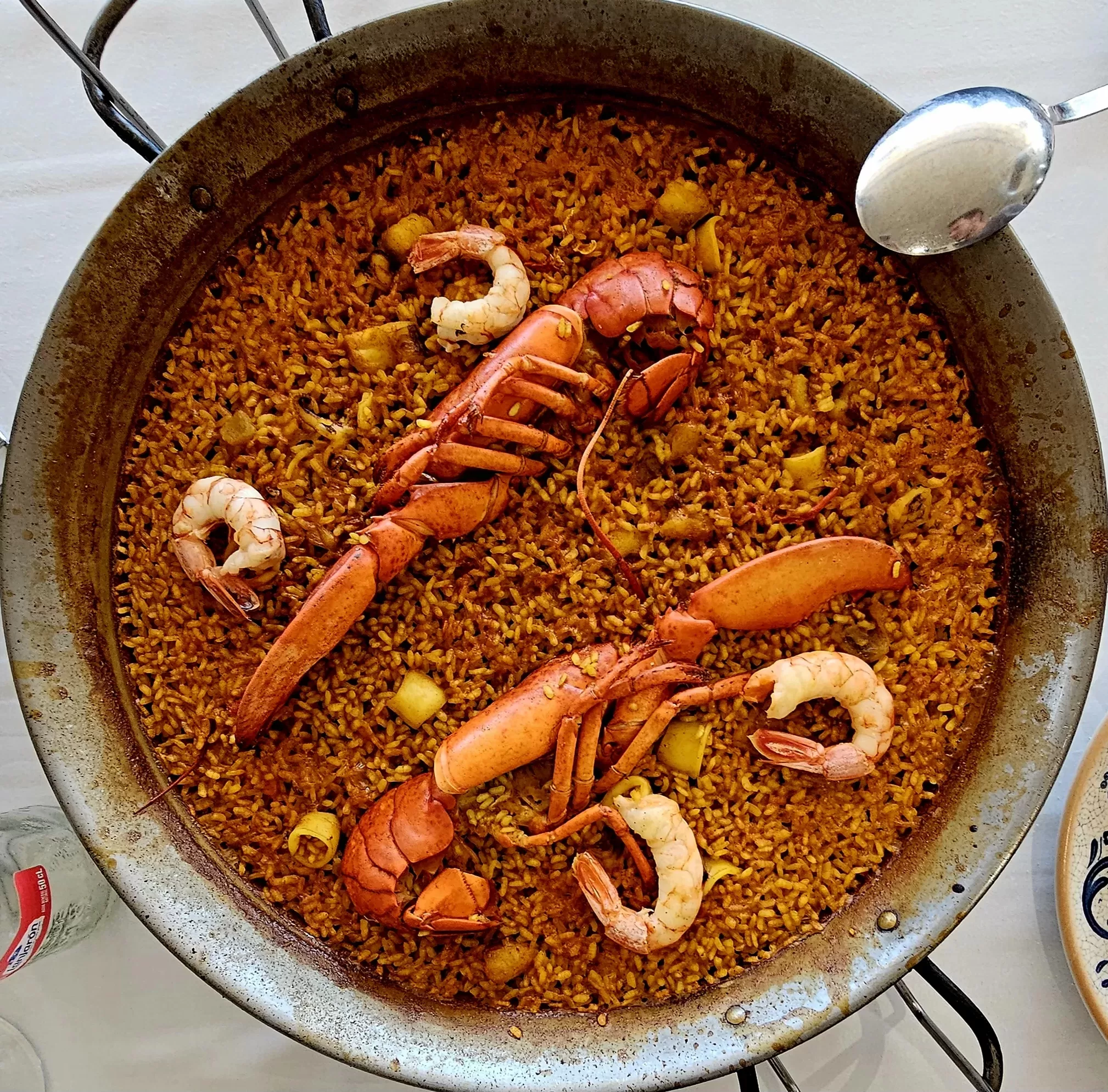 A pan full of rice and seafood on a table.