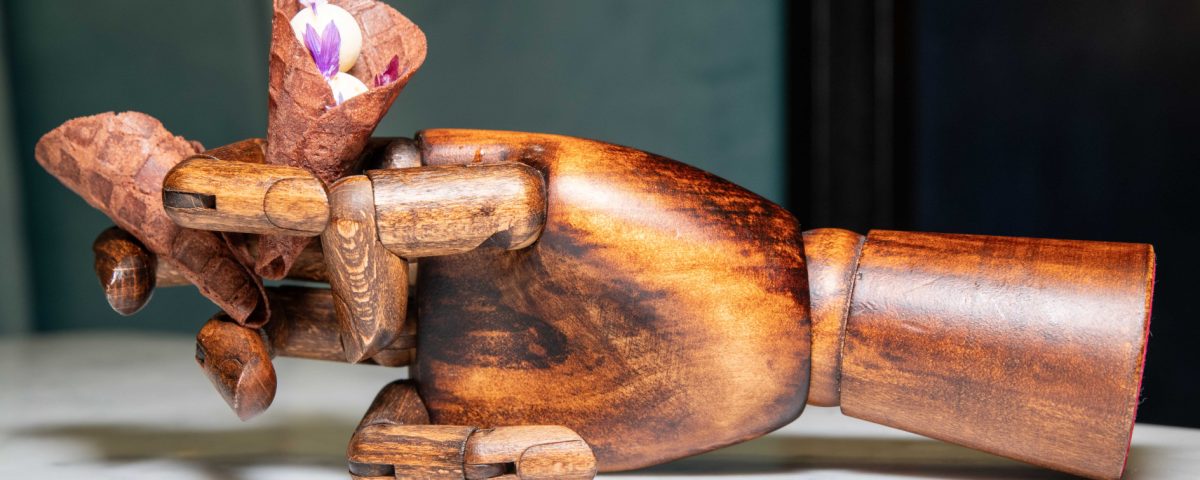 Epoka restaurant dish served on a decorative wooden hand